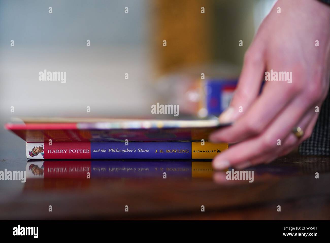 Der Auktionator Jim Spencer hält eine makellose Erstausgabe von JK Rowlings Harry Potter und der Stein der Weisen, einer von nur 500 Exemplaren, die 1997 in der ersten Auflage produziert wurden und bei Hansons' Auctioneers in der Bishton Hall, Staffordshire, zu sehen ist. Das Buch wurde nie gelesen und wurde 25 Jahre lang in einer Schutzhülle in Dunkelheit gehalten und konnte bis zu £100.000 holen, wenn es am 9. März bei der Hanson's Library Auction unter den Hammer geht. Bilddatum: Montag, 7. März 2022. Stockfoto