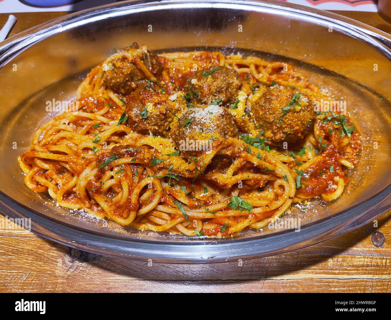 Teller mit Spaghetti mit Fleischbällchen auf einem Holztisch. Stockfoto
