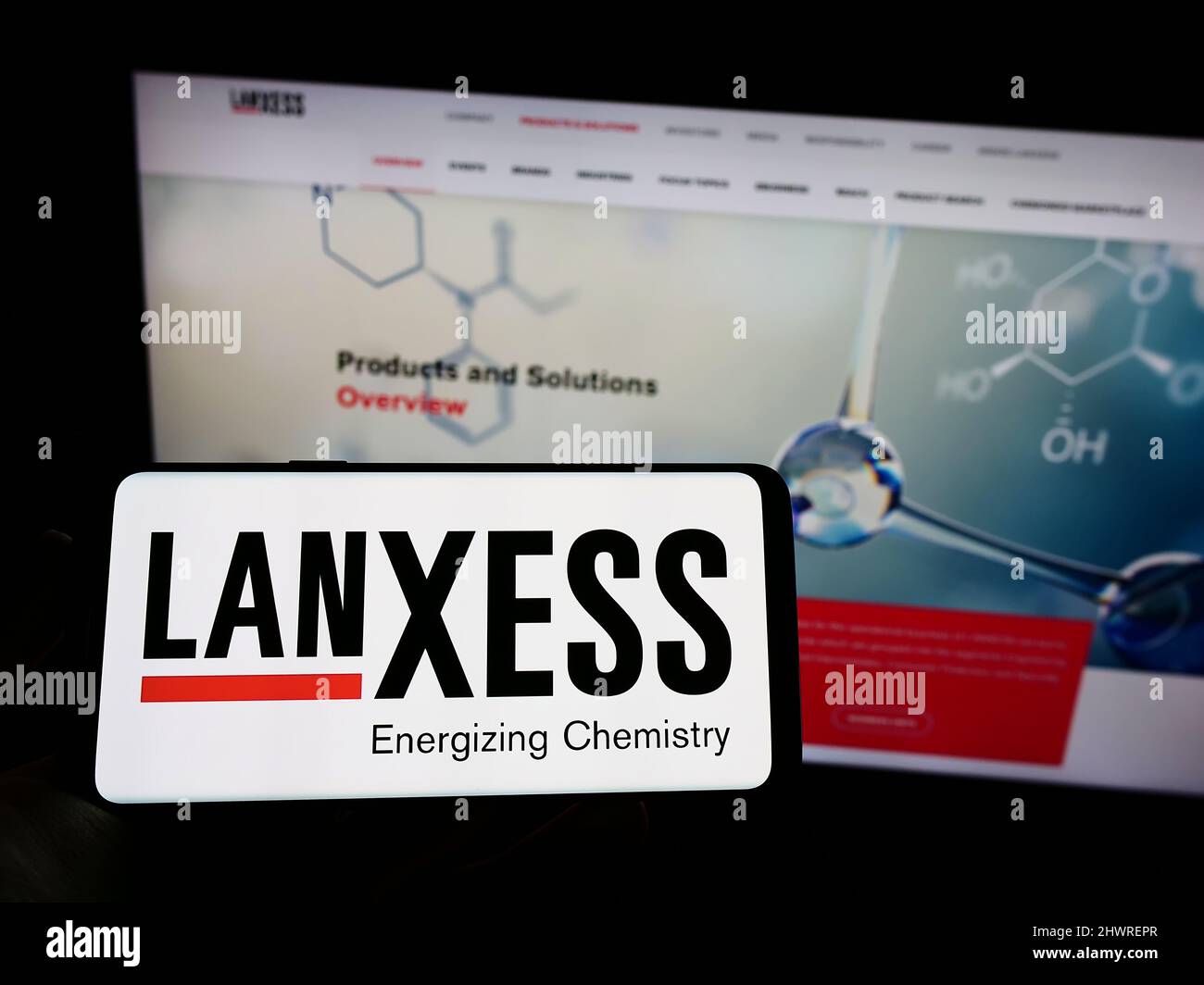 Person, die Mobiltelefon mit Logo des deutschen Chemieunternehmens Lanxess AG auf dem Bildschirm vor der Business-Webseite hält. Konzentrieren Sie sich auf die Telefonanzeige. Stockfoto