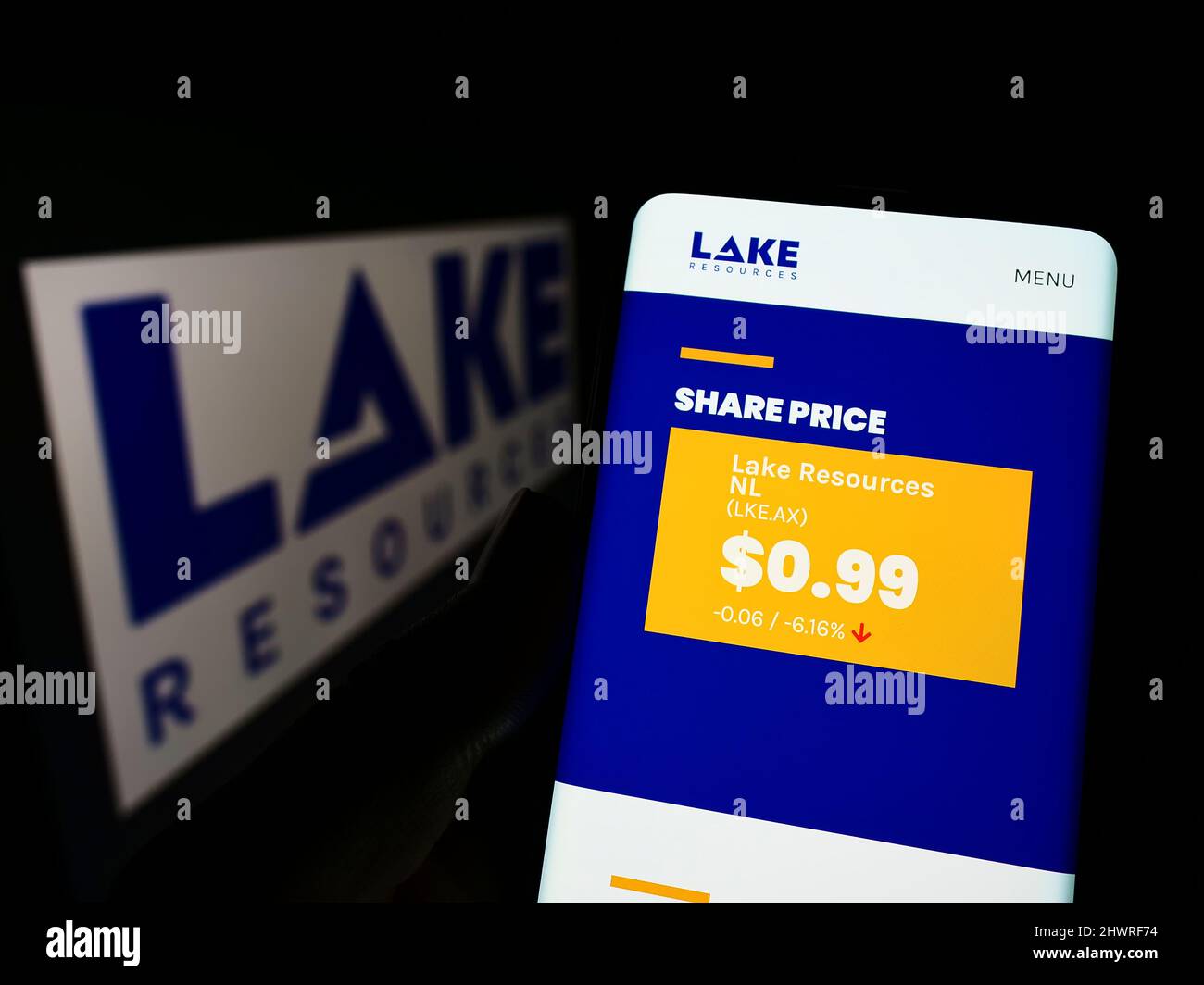 Person mit Mobiltelefon und Webseite des australischen Lithiumunternehmens Lake Resources N.L. auf dem Bildschirm mit Logo. Konzentrieren Sie sich auf die Mitte des Telefondisplays. Stockfoto
