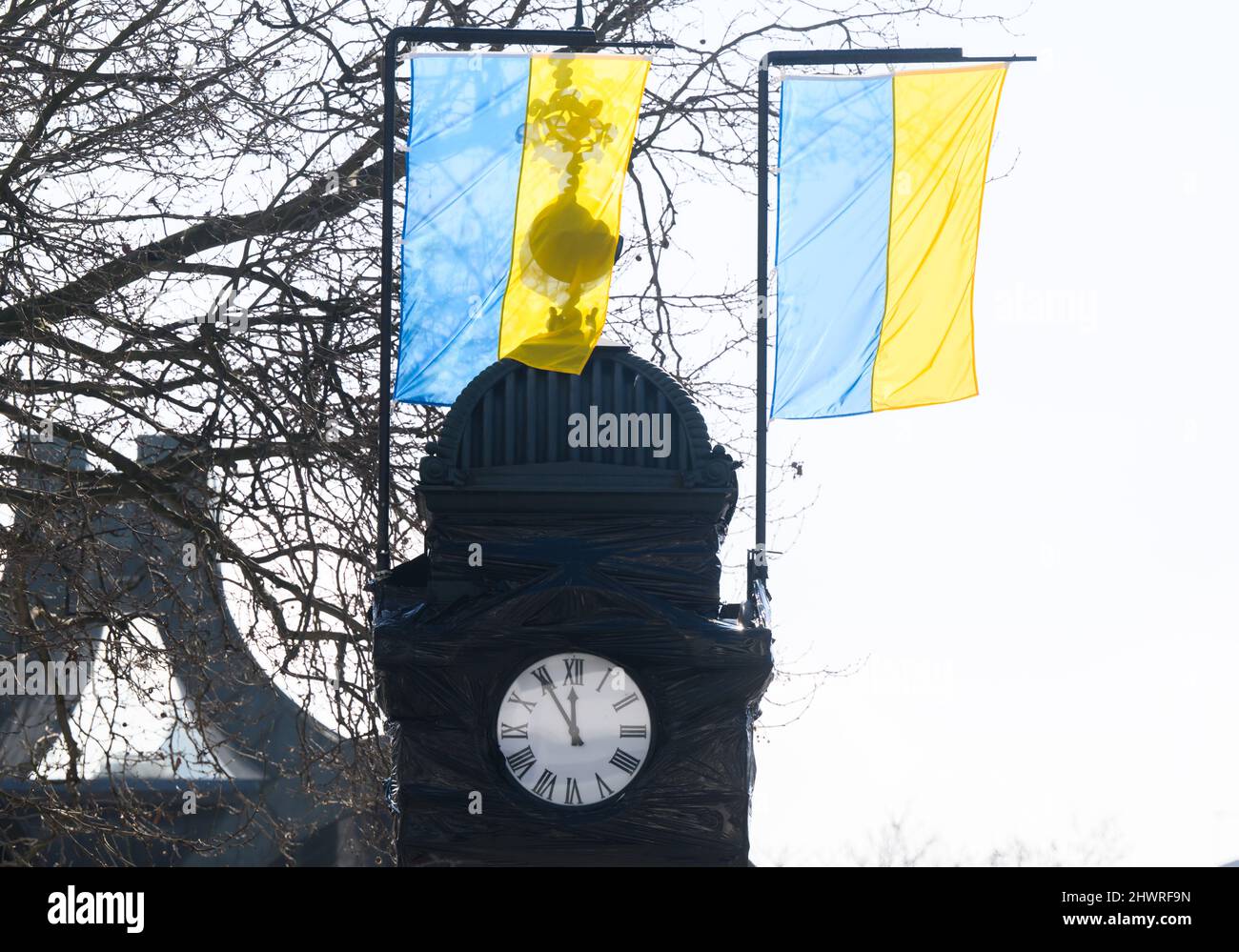 Hannover, Deutschland. 07. März 2022. Vor der Uhr in Kröpcke, die wegen des Ukraine-Krieges schwarz überzogen ist, fliegen zwei Flaggen der Ukraine mit fünf bis zwölf. Quelle: Julian Stratenschulte/dpa/Alamy Live News Stockfoto