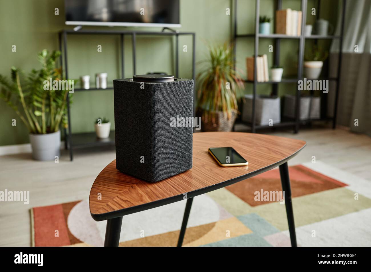 Hintergrundbild von Smart Speaker mit Home AI-System auf Holztisch im modernen Interieur, Kopierraum Stockfoto