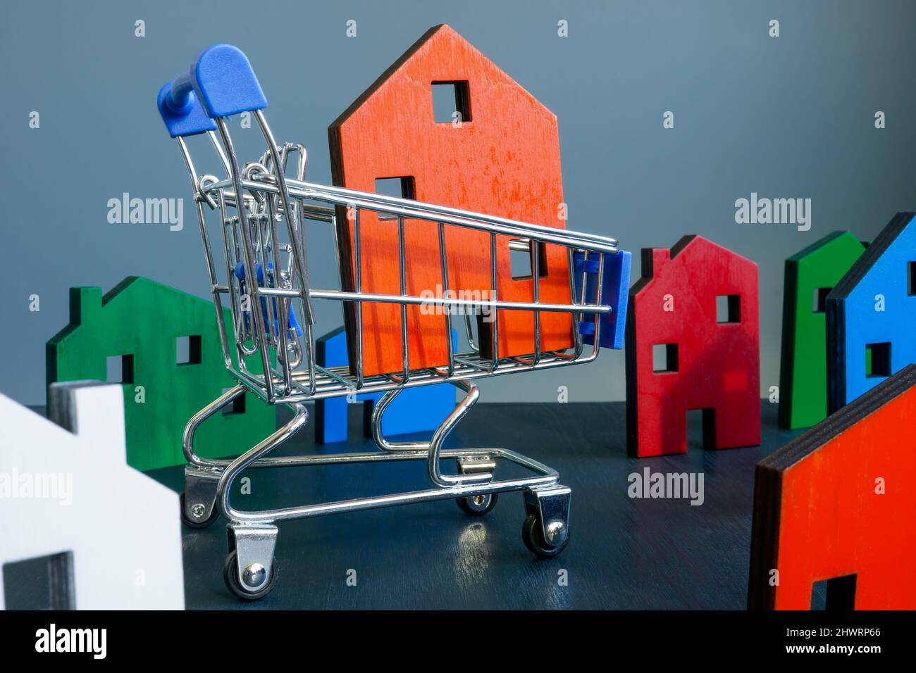 Kaufkonzept für Immobilien. Warenkorb und Modell des Hauses. Stockfoto