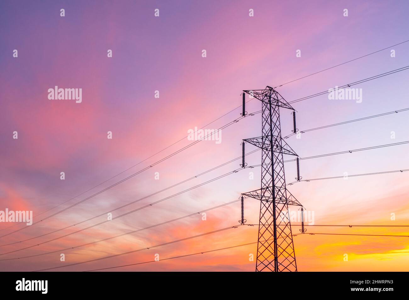 Ein niedriger Blickwinkel auf einen Metallmast, der Drähte mit großen Mengen an Energie transportiert, um Unternehmen und Wohnungen mit Energie und Kopierraum zu versorgen Stockfoto