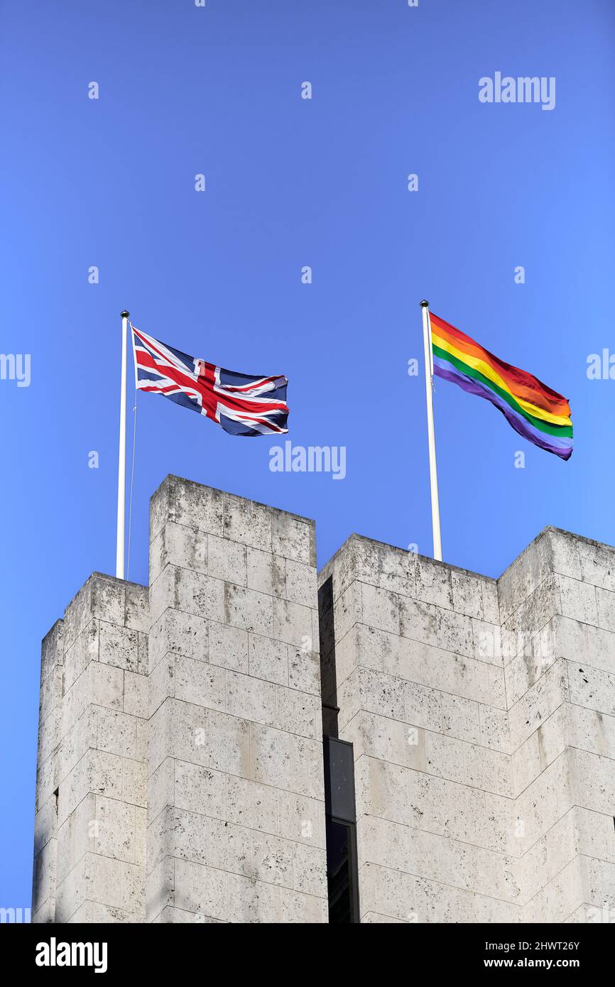 Die schwule (lgbt oder lgbtq+) Flagge flattert neben der Gewerkschaftsflagge auf dem Dach des britischen Arbeits- und Rentenministeriums, London, Stockfoto