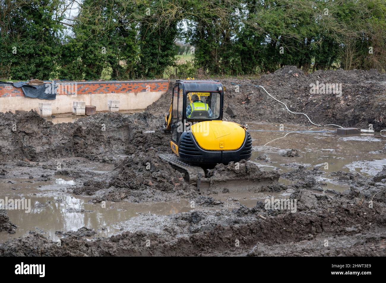 An einem Kanalbecken und angrenzenden Lagerhäusern werden von Freiwilligen in Wappenshall, Telford, Shropshire, Großbritannien, Restaurierungsarbeiten durchgeführt Stockfoto