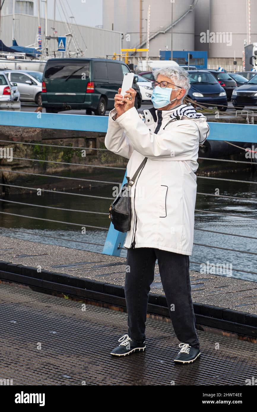 Eine ältere Frau macht ein Foto mit ihrem Smartphone Stockfoto