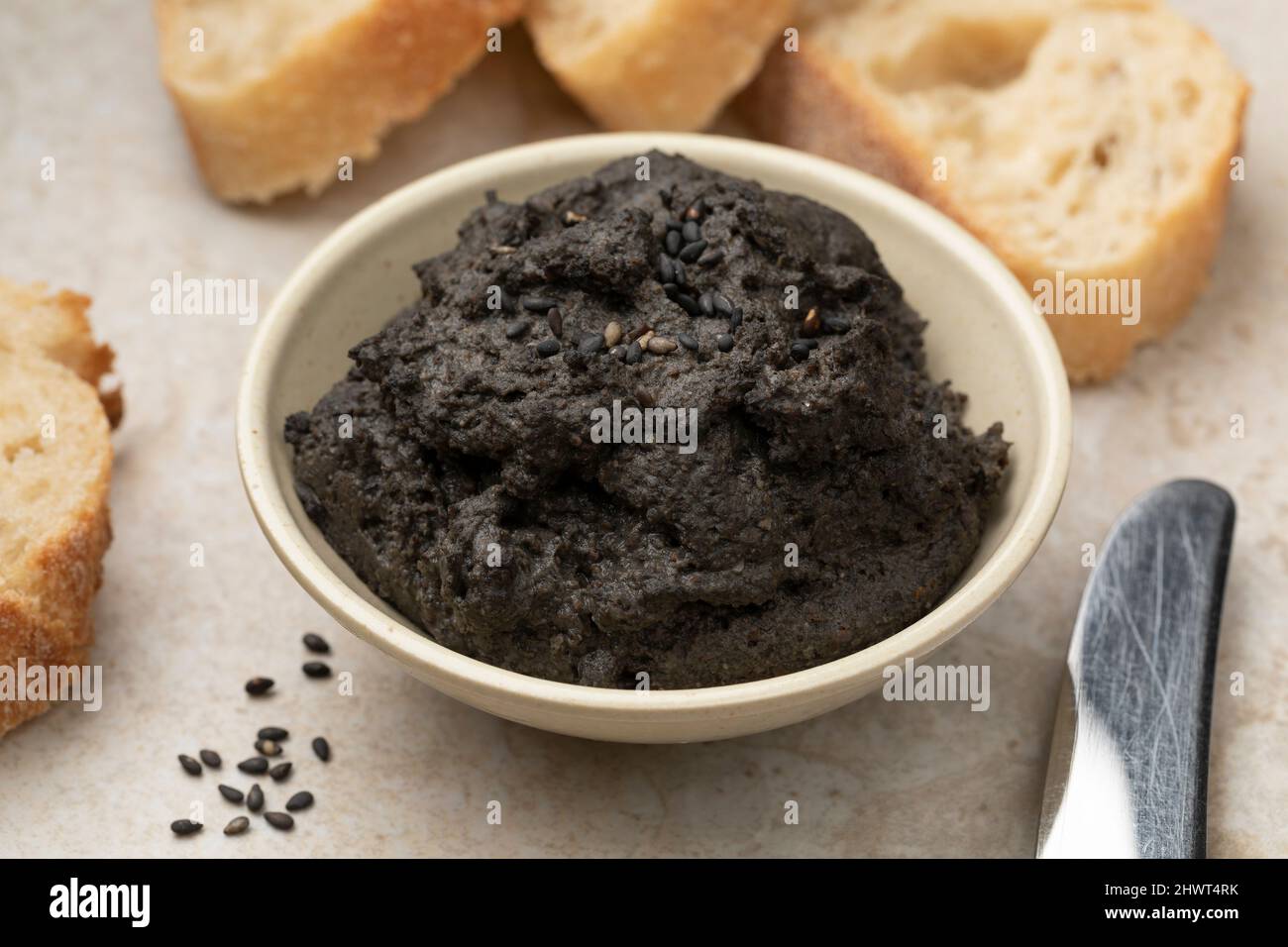 Schüssel mit frisch zubereitetes schwarzes Hummus aus nächster Nähe als Vorspeise Stockfoto