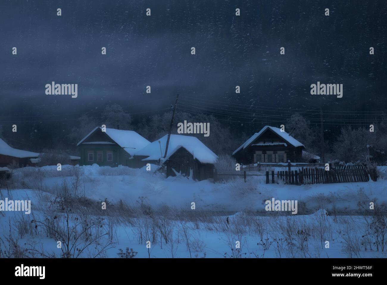 Altes Dorf mit Holzhäusern in einer Winternacht in den nebligen Bergen Stockfoto