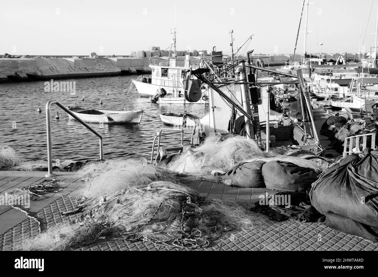 Fischerboote im alten Jaffa Hafen, Tel Aviv-Yafo, Israel. Fischnetz im Vordergrund. Historisches Foto in Schwarzweiß Stockfoto