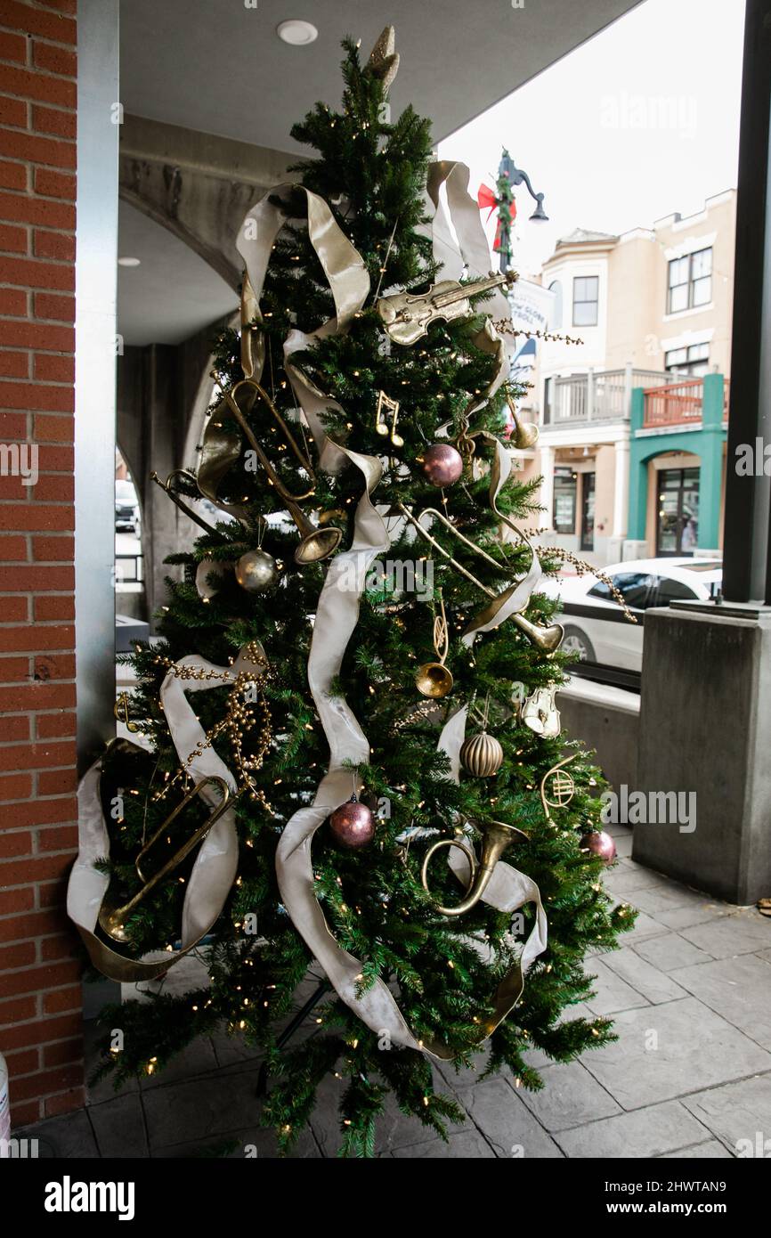 Ein großer geschmückter Weihnachtsbaum im Freien mit fließendem Band Stockfotografie