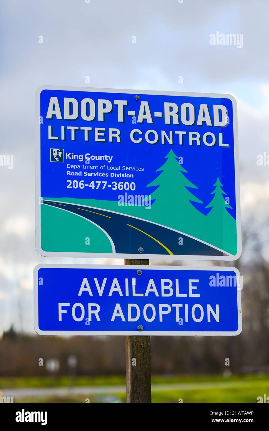 Fall City, WA, USA - 03. März 2022; Zeichen für Adopt a Road Litter Control in King County. Die Beschilderung ist mit einer Kontaktnummer verfügbar. Stockfoto
