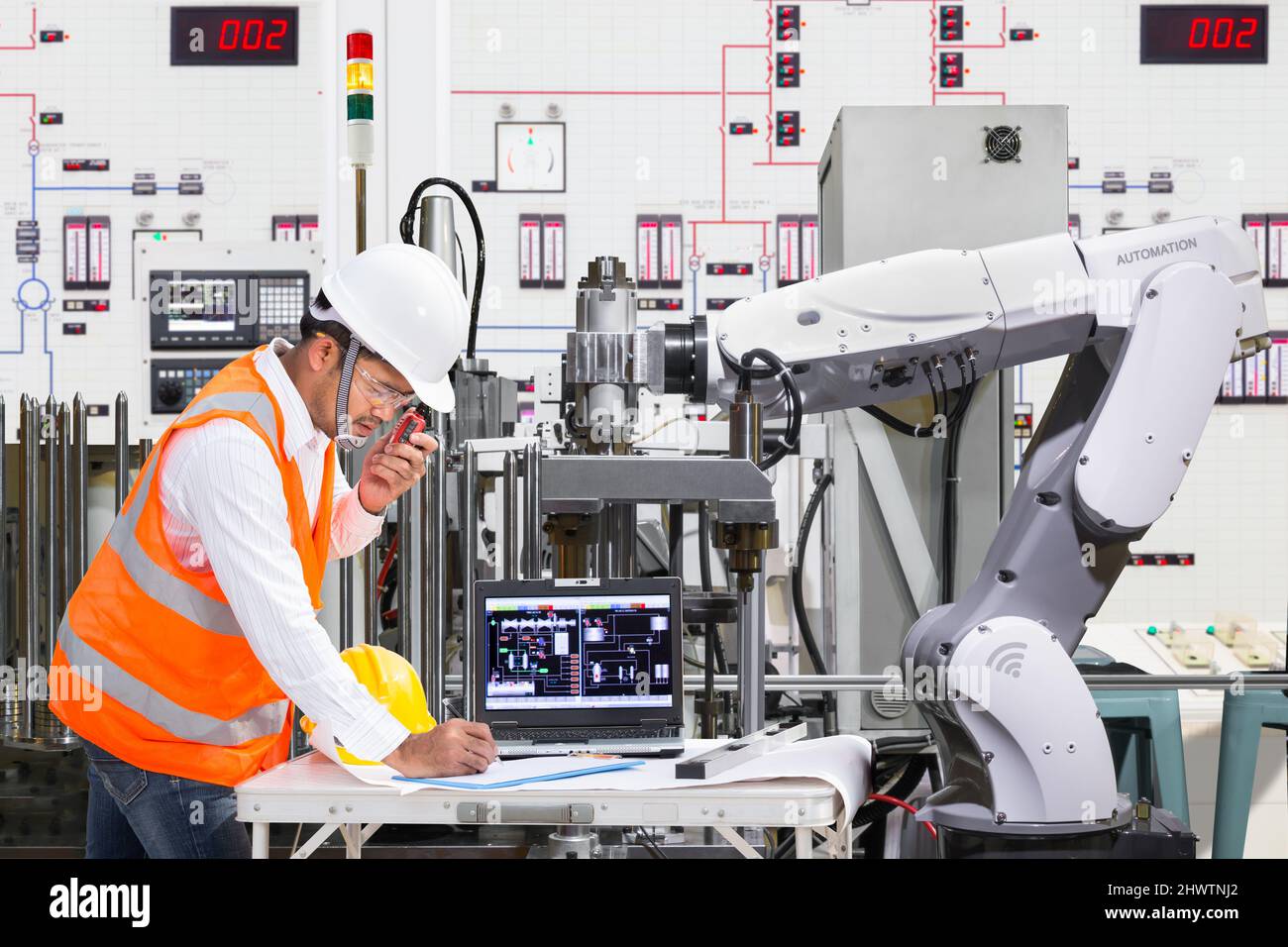 Ingenieur mit Laptop-Computer für die Wartung automatische Roboter-Handmaschine Werkzeug in der industriellen Fertigung Stockfoto