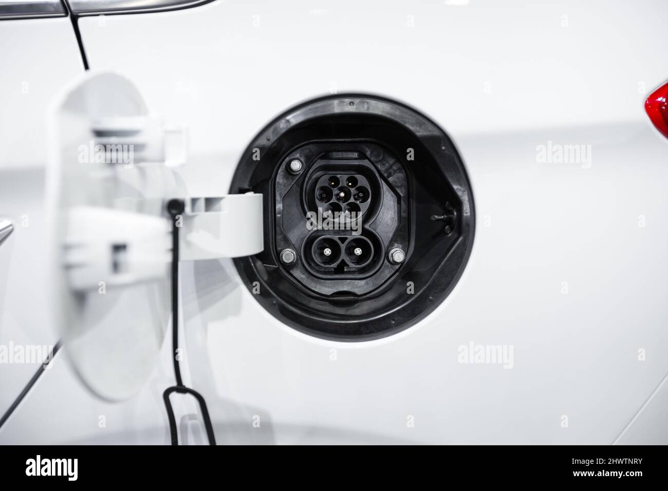 Nahaufnahme des elektrischen Steckers eines weißen Elektroautos Stockfoto