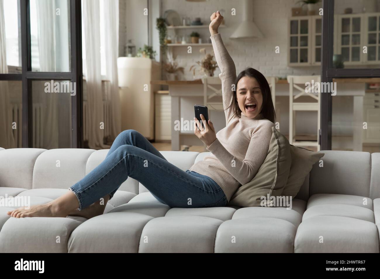 Frau hält Handy lesen unglaublich gute Nachrichten fühlt sich glücklich Stockfoto
