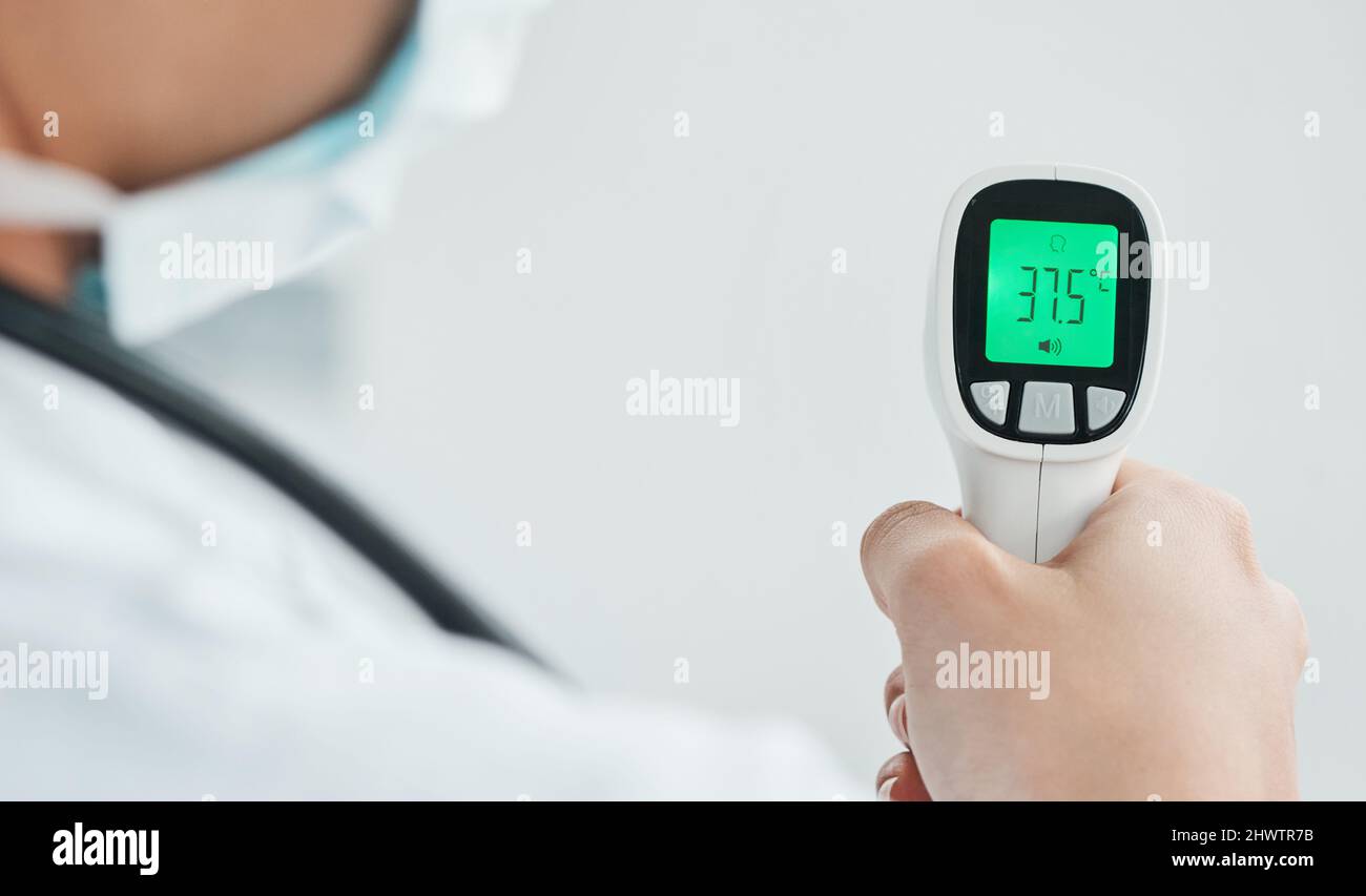 Das Temperaturscreening wird für alle Personen durchgeführt, die unser Krankenhaus betreten. Ausgeschnittene Aufnahme eines Arztes mit einem Infrarot-Thermometer. Stockfoto
