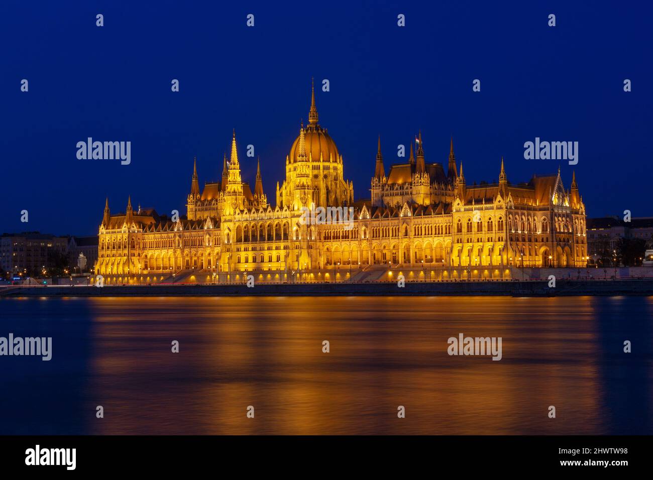 Das ungarische Parlamentsgebäude, ein bemerkenswertes Wahrzeichen Ungarns in Budapest. Blick auf die Hauptfassade beleuchtet über der Donau. Langes Exposur Stockfoto