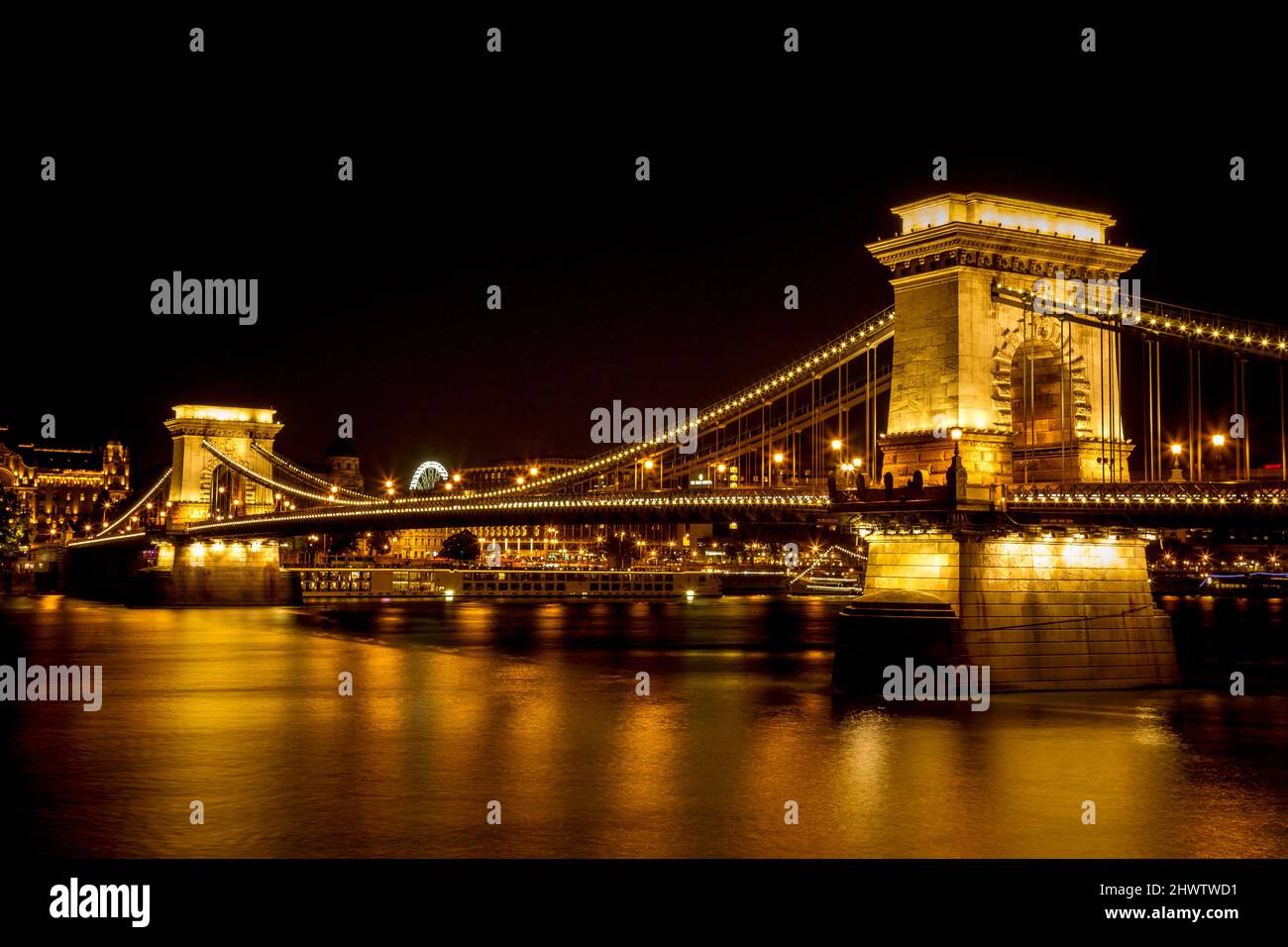 Die berühmte Széchenyi Kettenbrücke in Budapest, Ungarn, beleuchtet über der Donau. Lange Belichtung mit leichten Spuren von Autos in einer Nacht. Stockfoto
