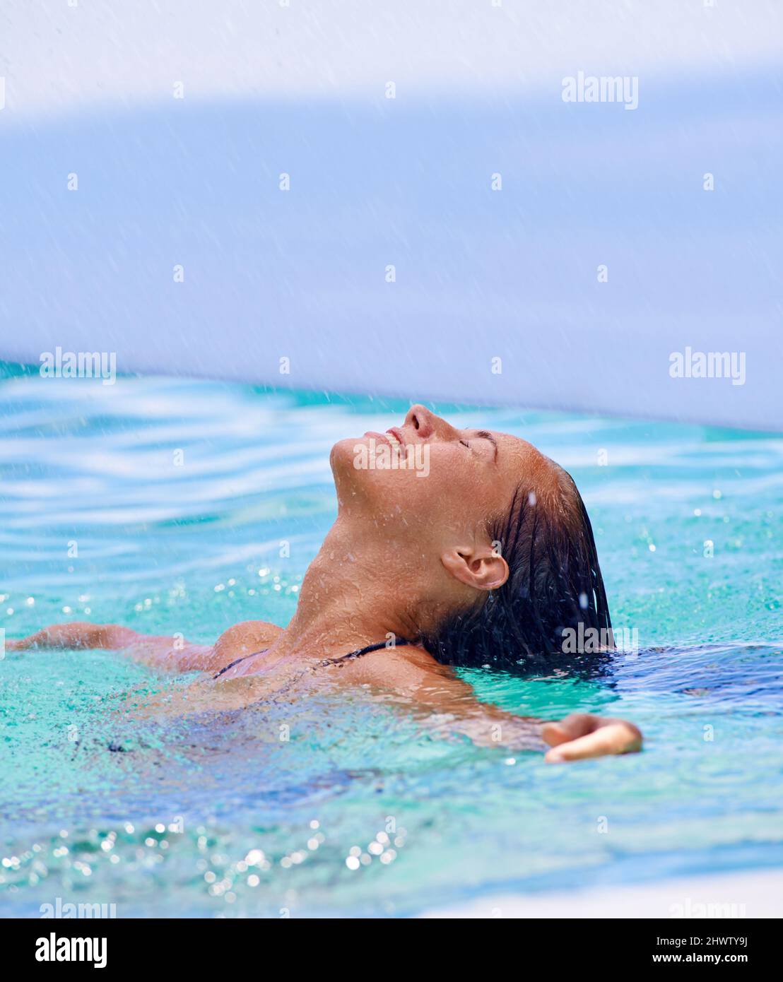 Mit einem tropischen Bad. Nahaufnahme einer Frau, die im Schwimmbad schwimmt. Stockfoto