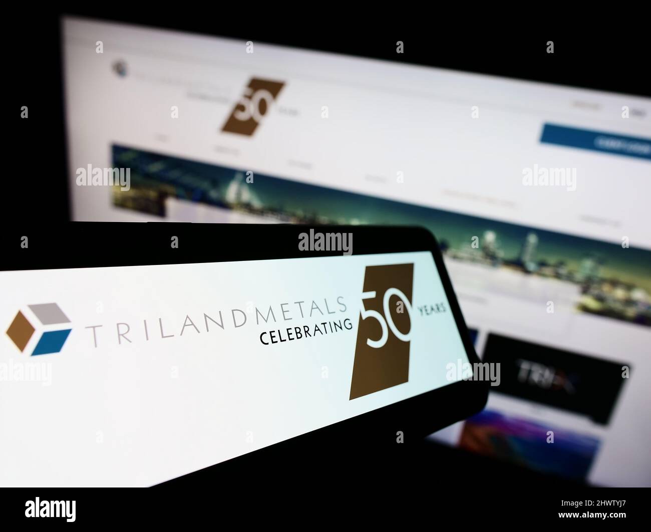 Handy mit Logo des britischen Unternehmens Triland Metals Limited auf dem Bildschirm vor der Business-Website. Konzentrieren Sie sich auf die Mitte des Telefondisplays. Stockfoto