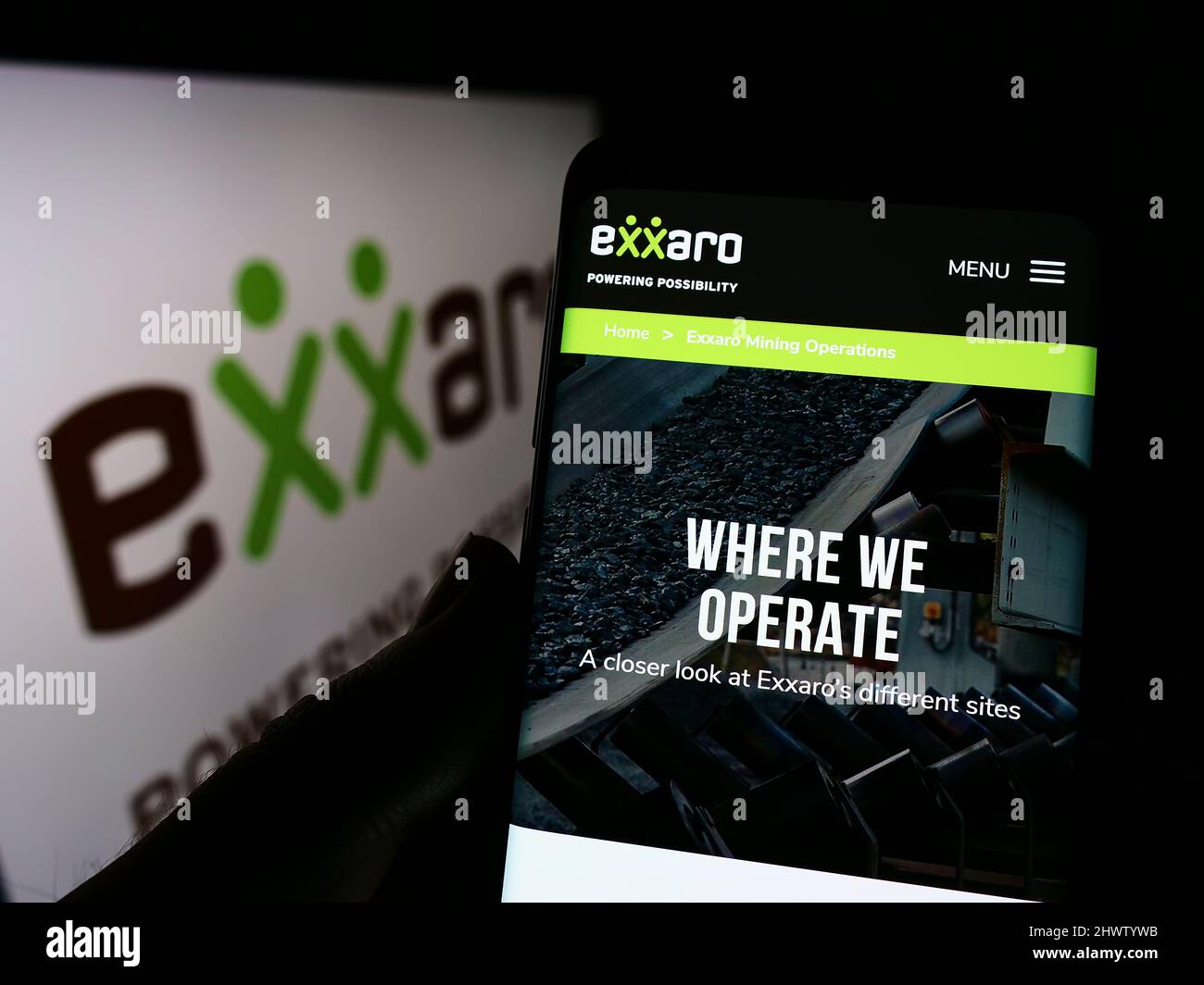 Person mit Mobiltelefon und Webseite des südafrikanischen Unternehmens Exxaro Resources Limited auf dem Bildschirm mit Logo. Konzentrieren Sie sich auf die Mitte des Telefondisplays. Stockfoto
