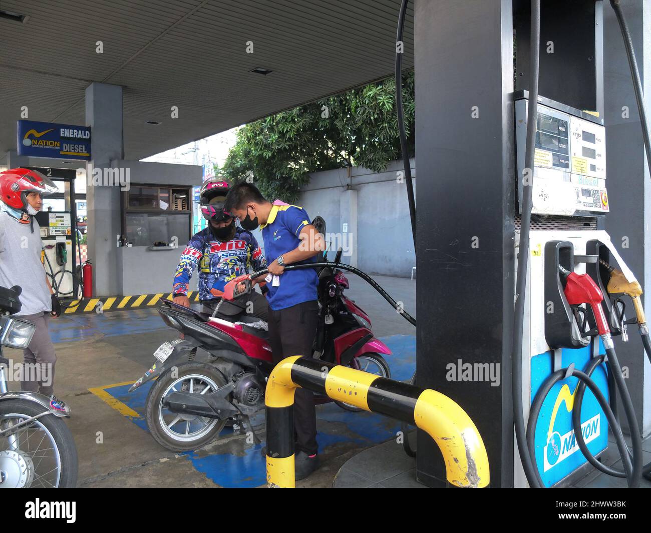 Der Benzin-Assistent zieht seine Gaspumpe und es ist Schlauch, um den Kraftstofftank des Motorrads zu erreichen. Die Philippinen erleben während des Russland-Ukraine-Konflikts steigende Preise für Öl und andere Kraftstoffprodukte. Das Energieministerium warnt die Öffentlichkeit, sich in den kommenden Tagen auf viel höhere Kraftstoffkosten zu gefasst zu machen. Sie sagten, dass dieser Preisverfall nicht nur auf den Philippinen, sondern auch in anderen Teilen der Welt stattfindet. Die philippinische Regierung bereitet einen Notfallplan vor, um die Kraftstoffkosten für den öffentlichen Nahverkehr, die Landwirte und die Fischer zu subventionieren. Stockfoto