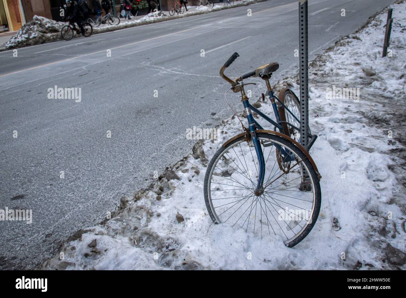 Ein Fahrrad, das teilweise durch Schnee in den Straßen von Toronto gefangen ist Stockfoto