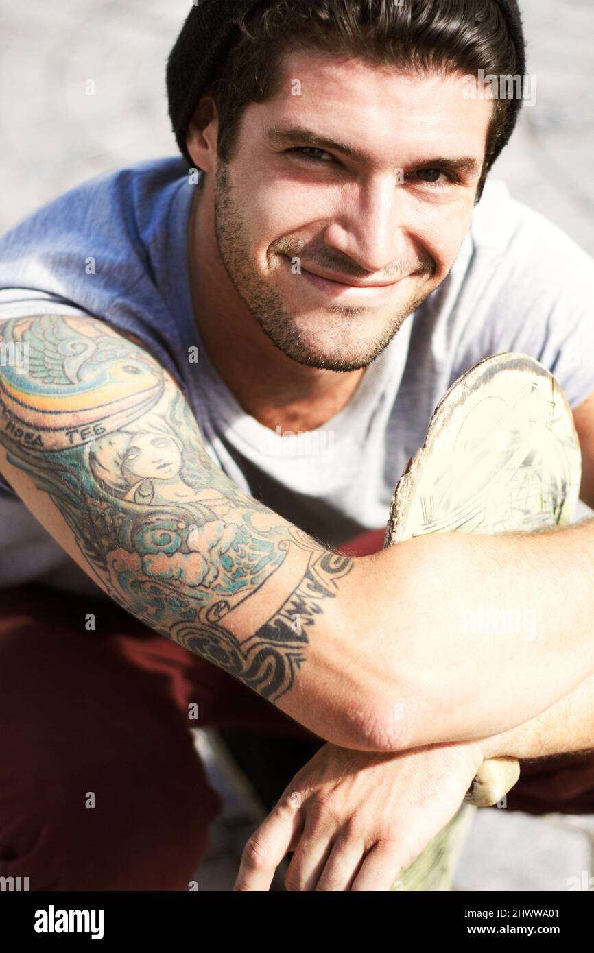 Dein Körper ist ein Tempel - dekoriere ihn. Porträt eines jungen Mannes, der sein wunderschönes Tattoo im Jugendstil zeigt. Stockfoto