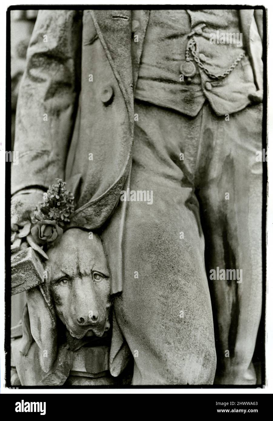 Detail eines Hundes an der Seite seines Meisters in einer Statue auf dem Friedhof Pere Lachaise in Paris, Frankreich Stockfoto