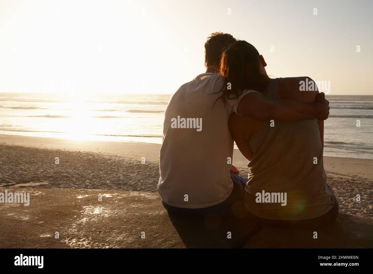Das Leben ist perfekt mit dir an meiner Seite. Silhouette eines Paares, das am Strand nebeneinander sitzt. Stockfoto