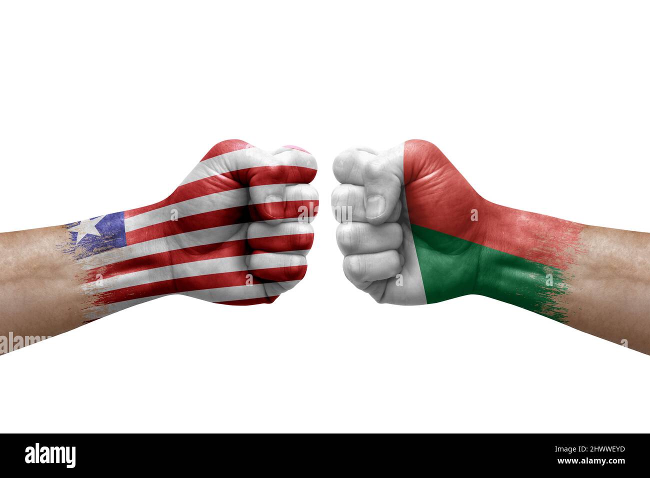 Zwei Hände schlagen sich gegenseitig auf weißem Hintergrund zu. Länderflaggen bemalten Fäuste, Konfliktkrisenkonzept zwischen liberia und madagaskar Stockfoto