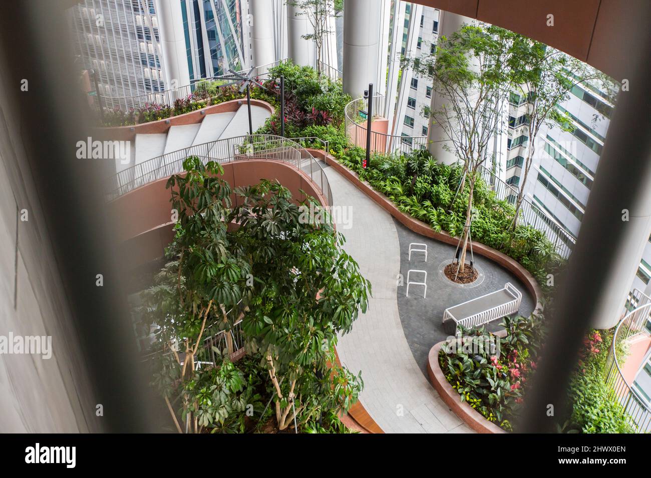 Top-Down-geometrisches Treppengitter mit Blick auf den grünen Oasis-Gartenentwurf im CapitaSpring, Downtown Raffles Place, Singapur. Stockfoto