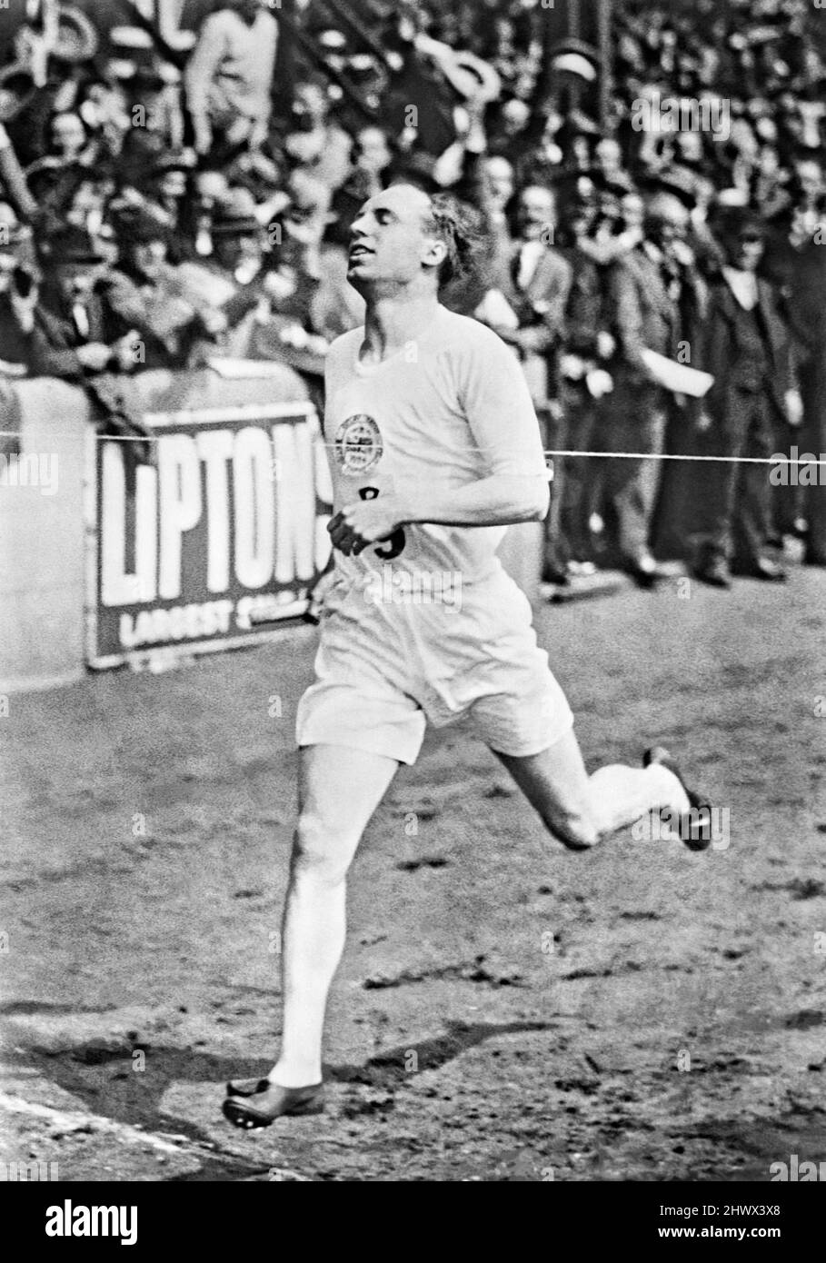 Der schottische Olympiateilnehmer Eric Liddell gewann die 1-Meilen-Staffel von British Empire gegen USA beim International Athletics Meeting, das am Samstag, den 19. Juli 1924, im Anschluss an die Olympischen Spiele in Paris, in der Stamford Bridge, London, stattfand. Aufgrund persönlicher Überzeugungen seines christlichen Glaubens weigerte sich Liddell bei den Olympischen Spielen 1924 bekanntermaßen, seine bevorzugten 100 Meter zu laufen, weil das Rennen an einem Sonntag stattfand. Stattdessen bestritt er das 400-Meter-Rennen, das er gewann. 1925 kehrte Liddell nach China zurück (wo er geboren wurde) und diente dort bis zu seinem Tod 1945 in einem japanischen zivilen Internierungslager als Missionar. Stockfoto