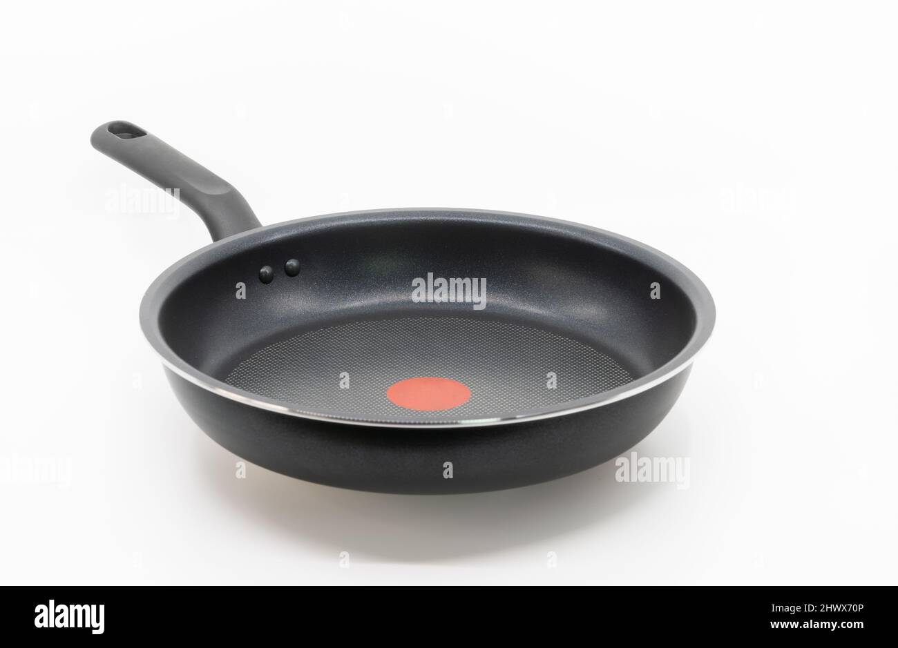 Schwarze Antihaft-Pfanne mit dem Griff auf weißem Hintergrund, leerer Platz auf der Pfanne, Blick von vorne. Stockfoto