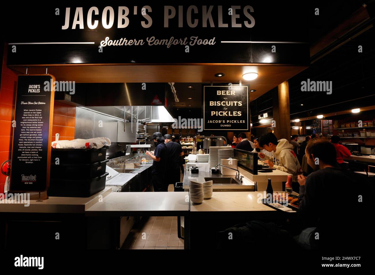Leute, die im Jacob's Pickles auf dem Time Out Market New York, 55 Water St, Brooklyn, NY, essen. Stockfoto