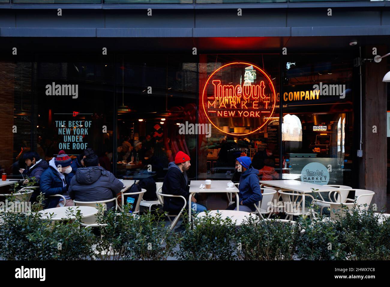 Menschen im Sitzbereich eines Cafés im Freien auf dem Time Out Market New York, 55 Water St, Brooklyn, NY. Eine Lebensmittelhalle im Viertel Dumbo. Stockfoto