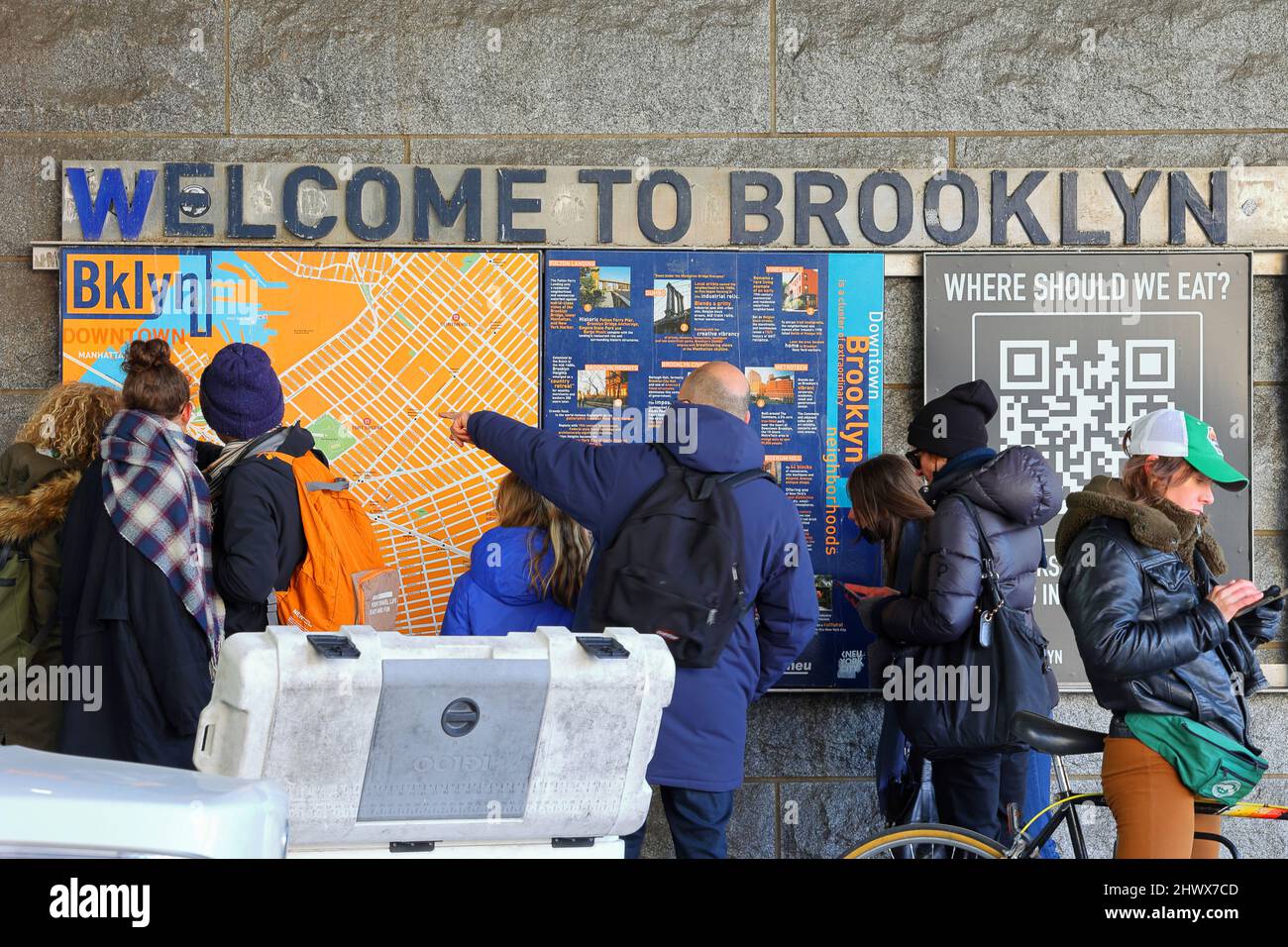 Touristen, die auf eine Karte von Brooklyn, New York, zeigen. Touristen, die sich eine Karte von Brooklyn ansehen, und Menschen, die am Telefon nach Wegbeschreibungen suchen. Stockfoto