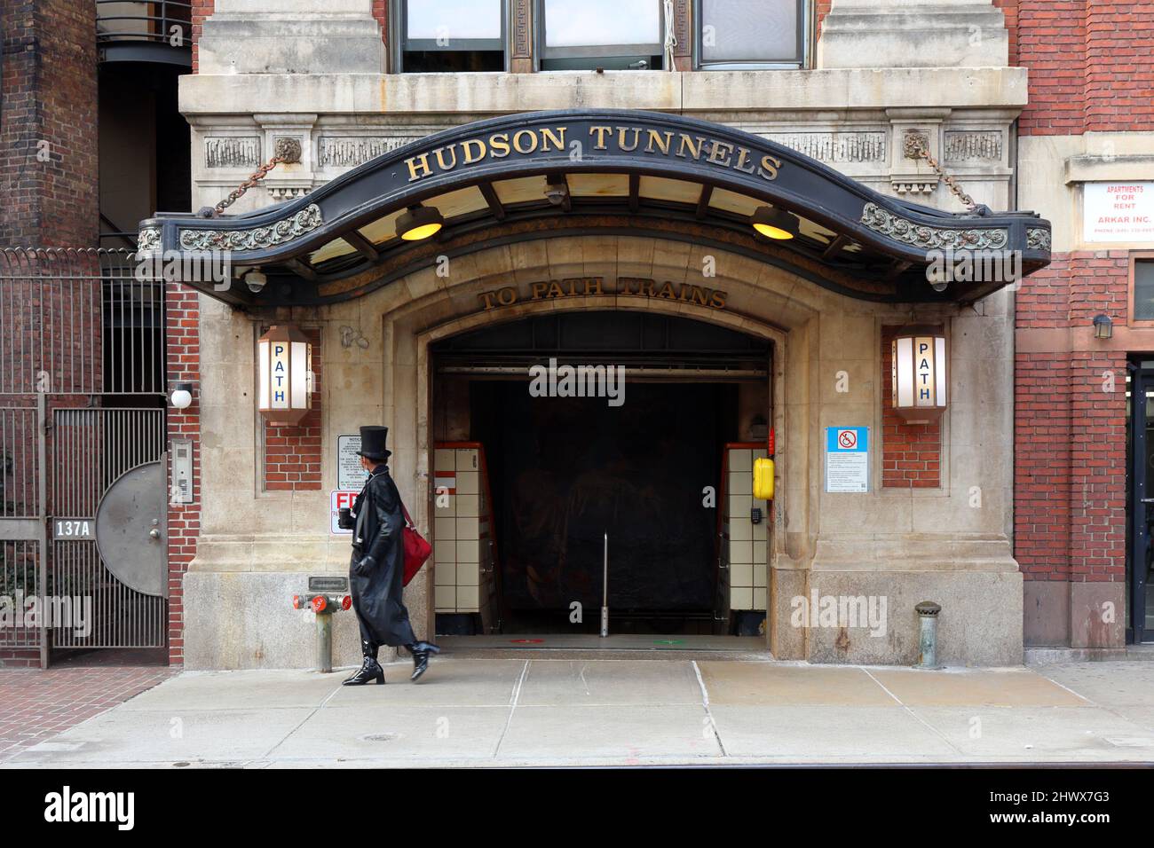 Eine Person mit einem Hut geht an der U-Bahn-Station Christopher St PATH im West Village Viertel von Manhattan, New York vorbei. Stockfoto Eine Person mit einem Hut geht an der U-Bahn-Station Christopher St PATH im West Village Viertel von Manhattan, New York vorbei. Stockfoto