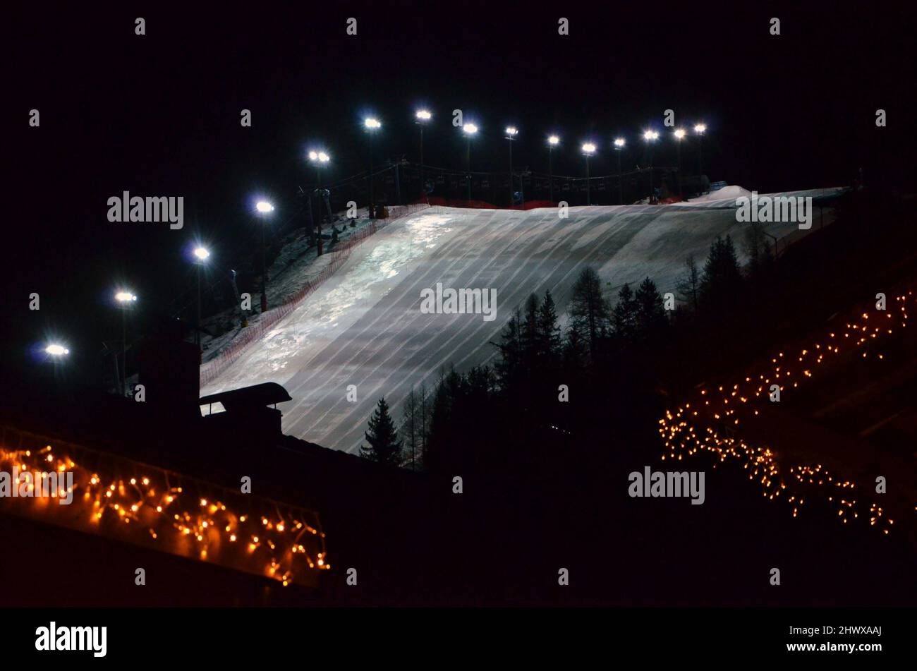 Fotos von den schneebedeckten Dolomiten während einer Wintertour, den kleinen Dörfern in den Bergtälern und den Skipisten bei Nacht Stockfoto