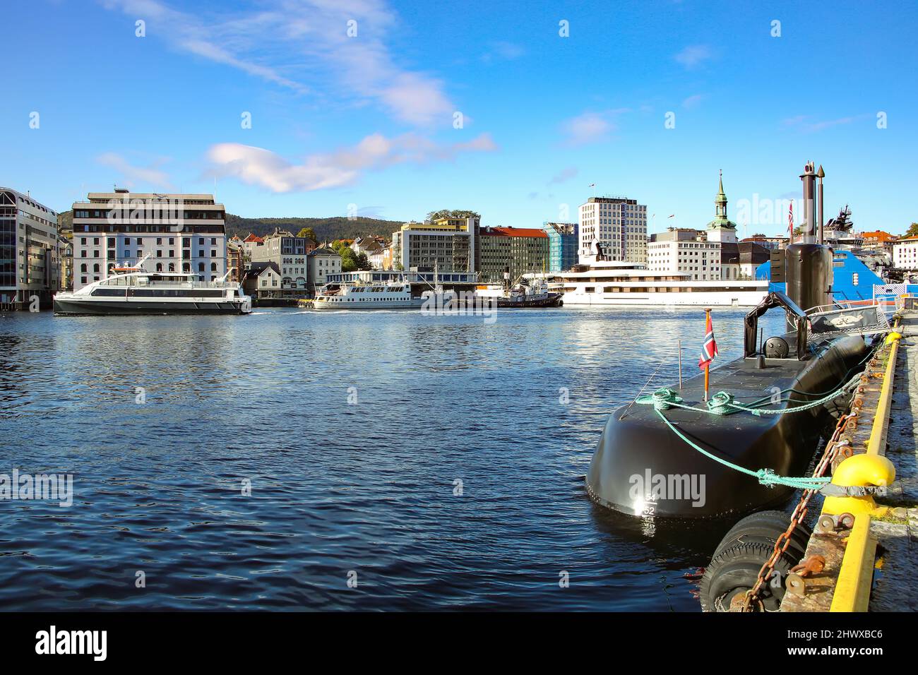 Blick auf den Hafen mit Booten, Fähren, Yachten und einem U-Boot mit den Stadtgebäuden im Hintergrund, Bryggen, Bergen, Norwegen. Stockfoto