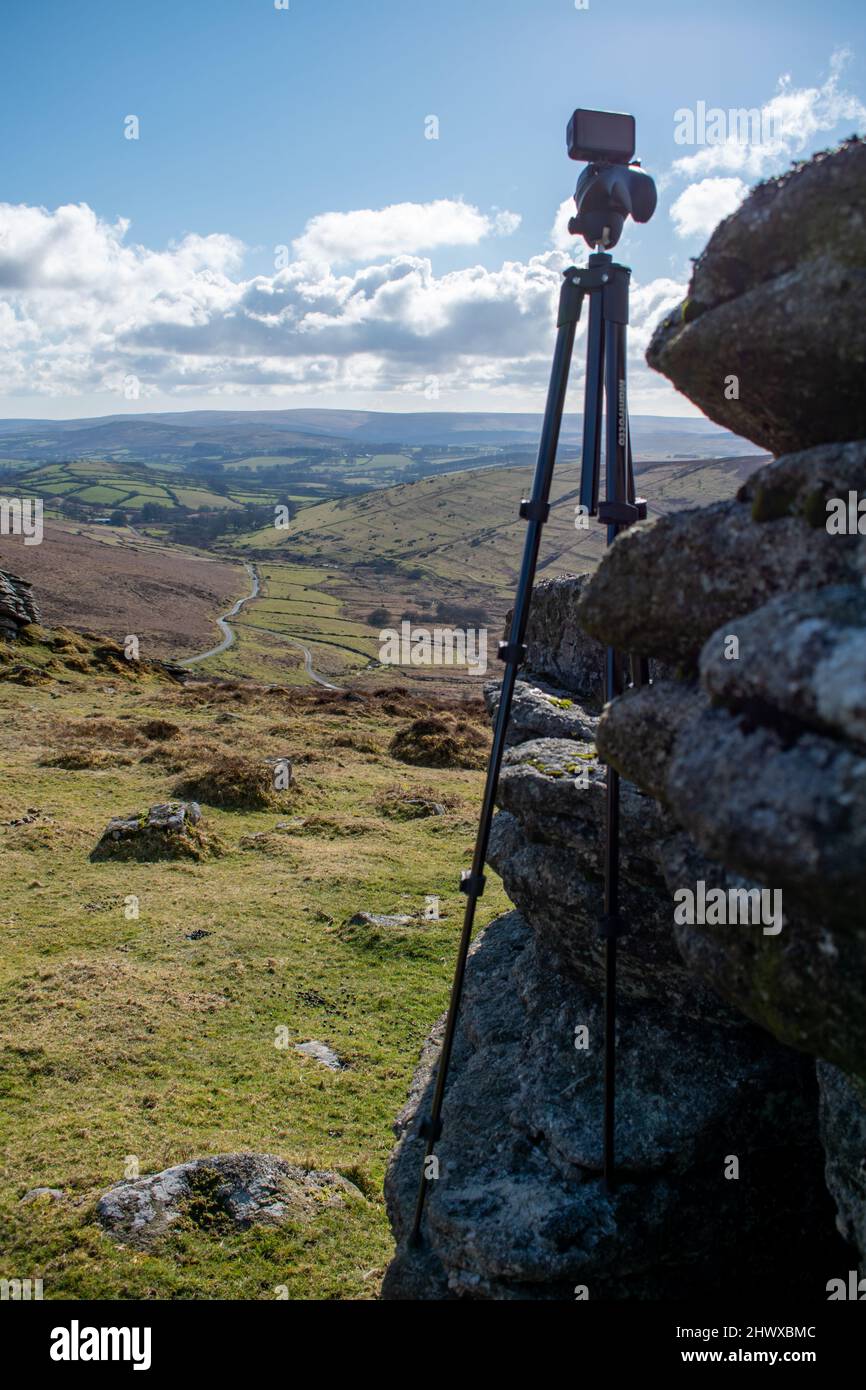 Eine schwarze Action-Kamera steht auf einem Stativ auf einem Granitfelsen im Dartmoor National Park, England. Stockfoto