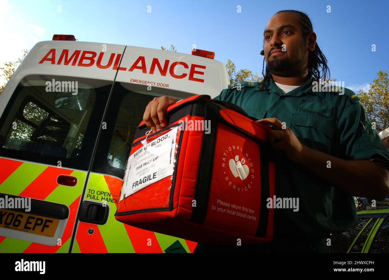 Ein Krankenwagentechniker, der eine Tasche mit gekühltem gespendetem Blut trägt (MODELL FREIGEGEBEN) Stockfoto