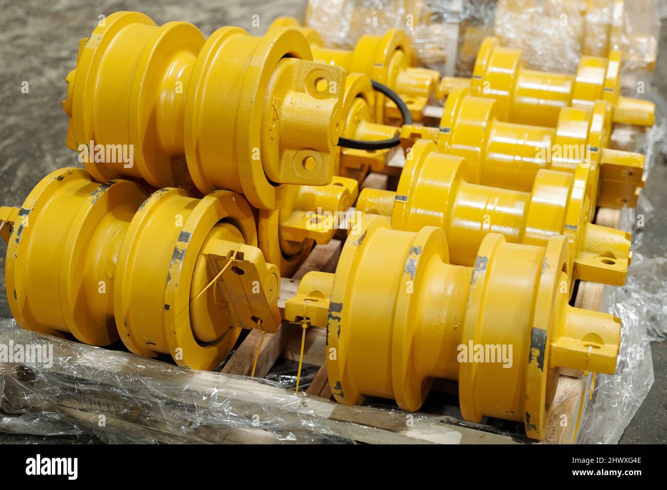 Gruppe von Ersatzteilen aus gelbem Metall für moderne Industrie- oder Baumaschinen, die in modernen Anlagen der Schwerindustrie hergestellt werden Stockfoto