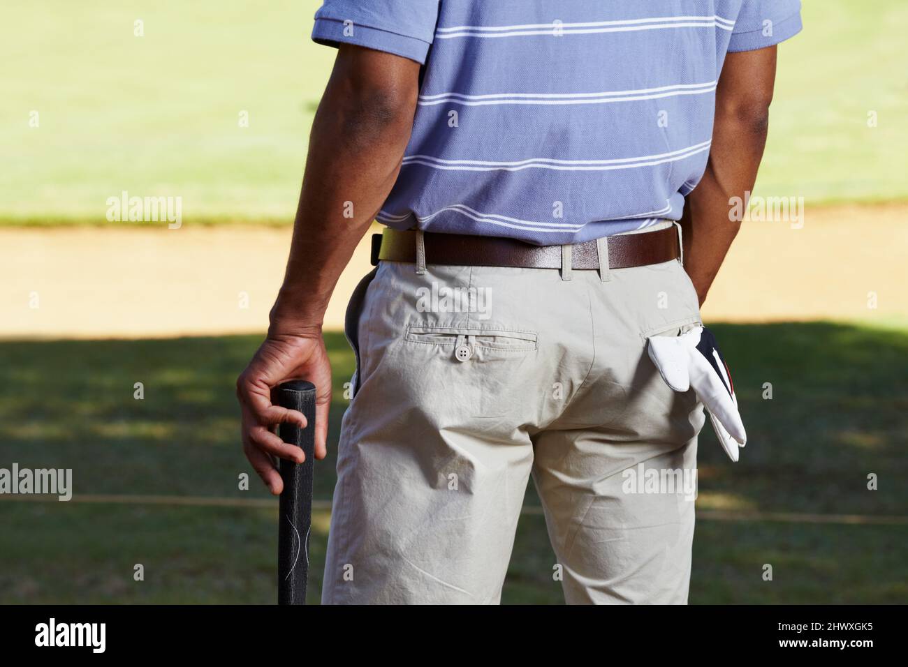 Warten auf seinen Abschlag. Rückansicht eines ausgeschnittenen Schusses eines Golfspielers im Mittelteil mit einem Handschuh, der aus seiner Gesäßtasche hing. Stockfoto