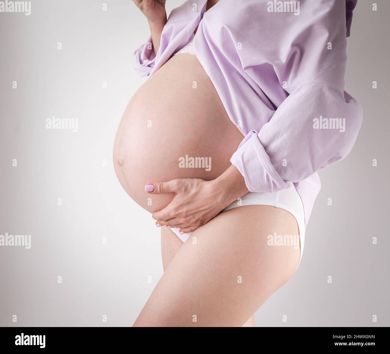 studioaufnahme eines Schwangeren Bauches auf weißem Hintergrund Stockfoto