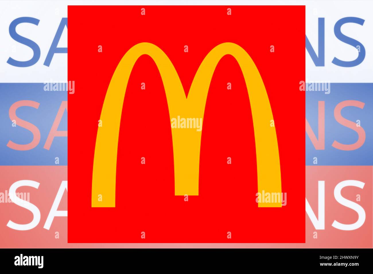McDonalds-Logo vor dem Sanktionstext auf der russischen Flagge. Neue Sanktionen gegen Russland wegen seiner Invasion in der Ukraine. Stockfoto