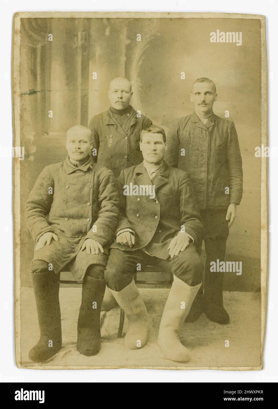 Original Albumin-Druck auf Karte aus dem 19.. Jahrhundert (kleines Schrankkartenformat) wahrscheinlich russisch - diese Gruppe von 4 Arbeiterinnen und Bauern trägt die typischen Filzstiefel Russlands, genannt Valenki, für harte Arbeit draußen in der eisigen Kälte. Circa 1880/1890, Russland. Stockfoto