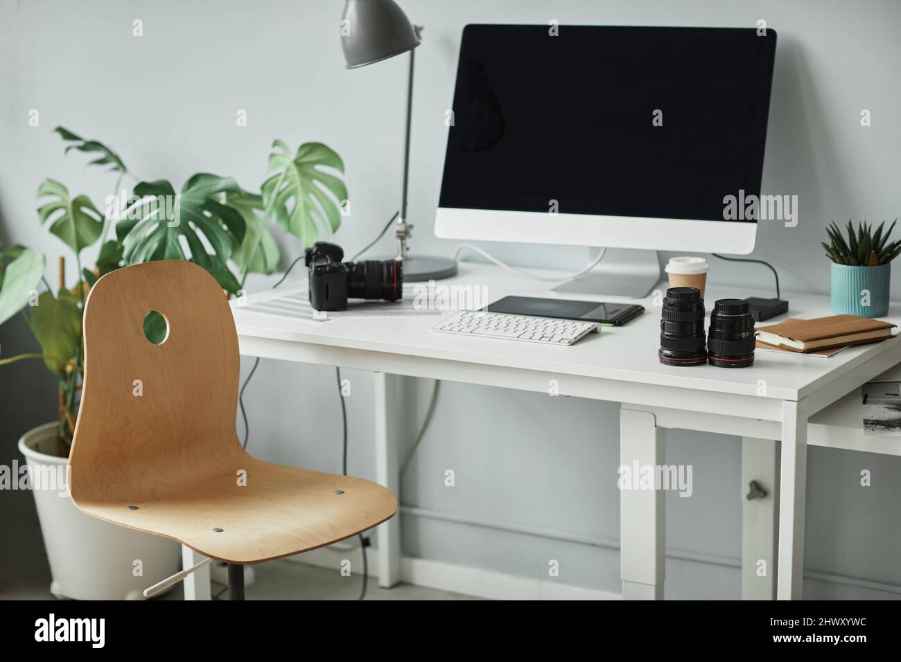 Hintergrundbild von minimalen Fotografen Arbeitsplatz mit Computer für die Fotobearbeitung eingerichtet Stockfoto