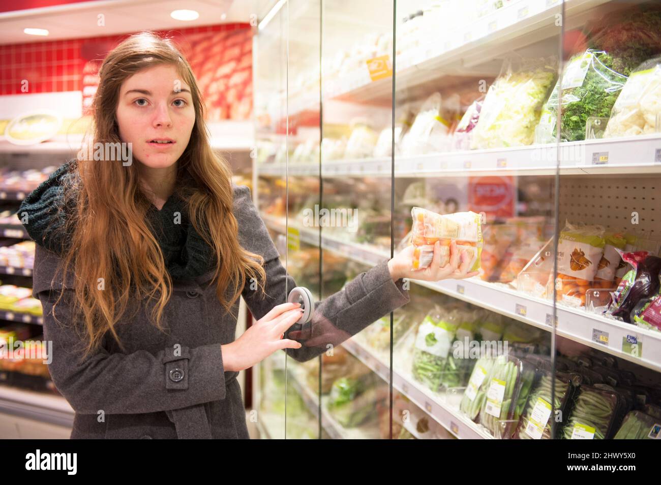 Tilburg, Niederlande., Junge Erwachsene Frau besucht den lokalen Supermarkt Top kaufen und kaufen Lebensmittel und Lebensmittel für einen gesundheitlichen Lebensstil. Stockfoto
