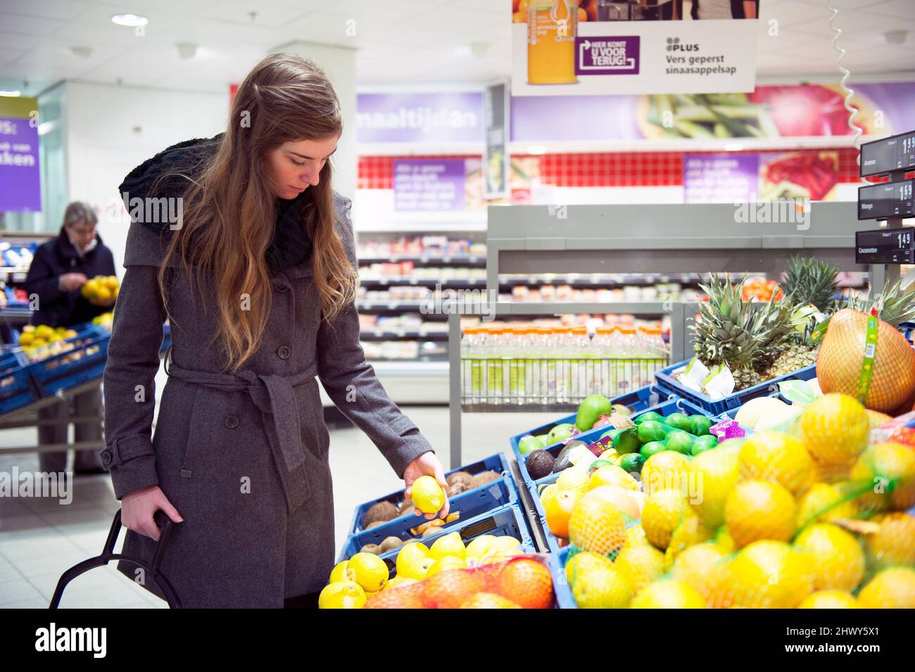 Tilburg, Niederlande., Junge Erwachsene Frau besucht den lokalen Supermarkt Top kaufen und kaufen Lebensmittel und Lebensmittel für einen gesundheitlichen Lebensstil. Stockfoto